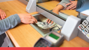 Persona recibe dinero en ventanilla de un banco.