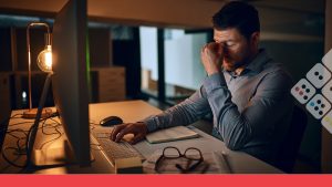 Trabajador frente a computadora cansado por jornada laboral